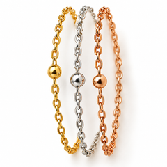 Three delicate chain bracelets in yellow gold, silver, and rose gold, each featuring a polished ball charm, arranged vertically on a clean white background.