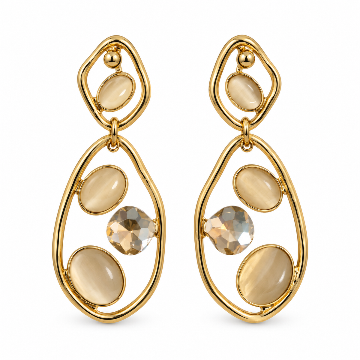 A pair of gold dangle earrings with oval and teardrop-shaped cream-colored stones and one faceted clear crystal, shown on a plain white background.