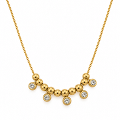 A gold necklace featuring a curved bar of polished gold beads with five small bezel-set clear round stones, displayed on a clean white background.