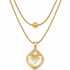 A gold double-layer necklace featuring a textured chain and a pendant with a white pearl sun motif set in a bamboo-like frame.