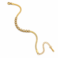 A gold snake chain bracelet featuring a row of bezel-set clear round stones, shown on a plain white background.