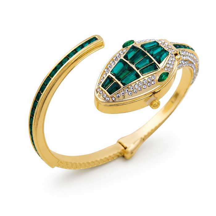 A gold hinged cuff bracelet featuring a stylized snake head motif set with emerald-cut green gemstones and pavé-set clear stones, shown on a clean white background.