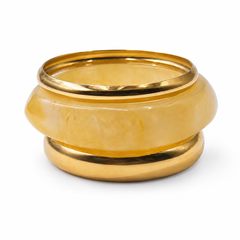 A gold-plated metal ring with a smooth, rounded translucent yellow stone inlay, photographed on a clean white background.