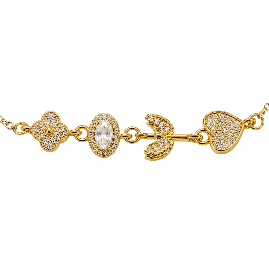 A gold chain necklace featuring a decorative bar with a four-leaf clover, an oval halo of small clear stones, a bird motif, and a heart-shaped pavé setting, all on a plain white background.