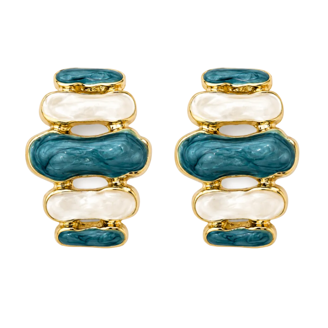 A pair of gold-plated earrings featuring stacked organic-shaped inlays of teal blue enamel and white mother-of-pearl.