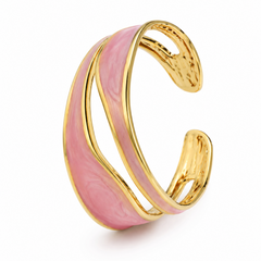 A gold-toned open cuff bracelet featuring a wavy, layered pink enamel inlay, shown on a clean white background.