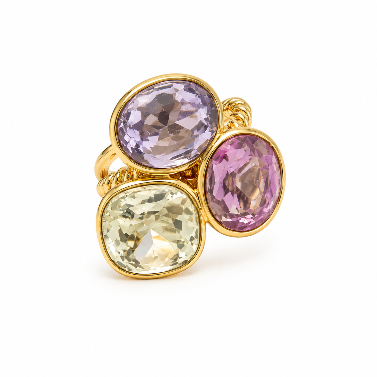 A gold ring featuring three large, bezel-set oval gemstones in lavender, pink, and pale yellow, arranged on a clean white background.