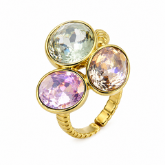 A gold-plated ring featuring three oval-cut iridescent gemstones in bezel settings, with one pale green stone, one lavender-pink stone, and one peach-toned stone, set against a plain white background.