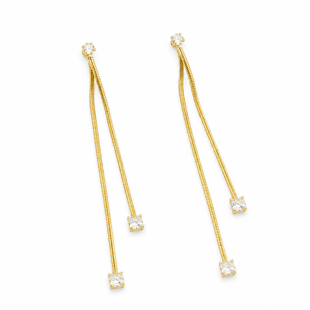 A pair of gold dangle earrings with textured snake-chain drops and square clear gemstones at the ends, shown on a plain white background.