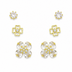 A set of gold and clear crystal flower-shaped stud earrings arranged on a plain white background, including smaller round and larger petal clusters.