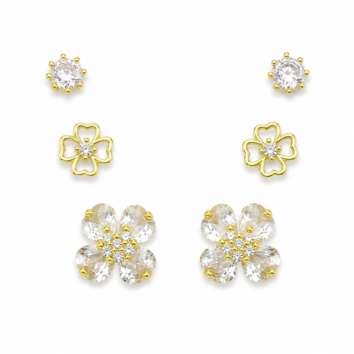 A set of gold and clear crystal flower-shaped stud earrings arranged on a plain white background, including smaller round and larger petal clusters.