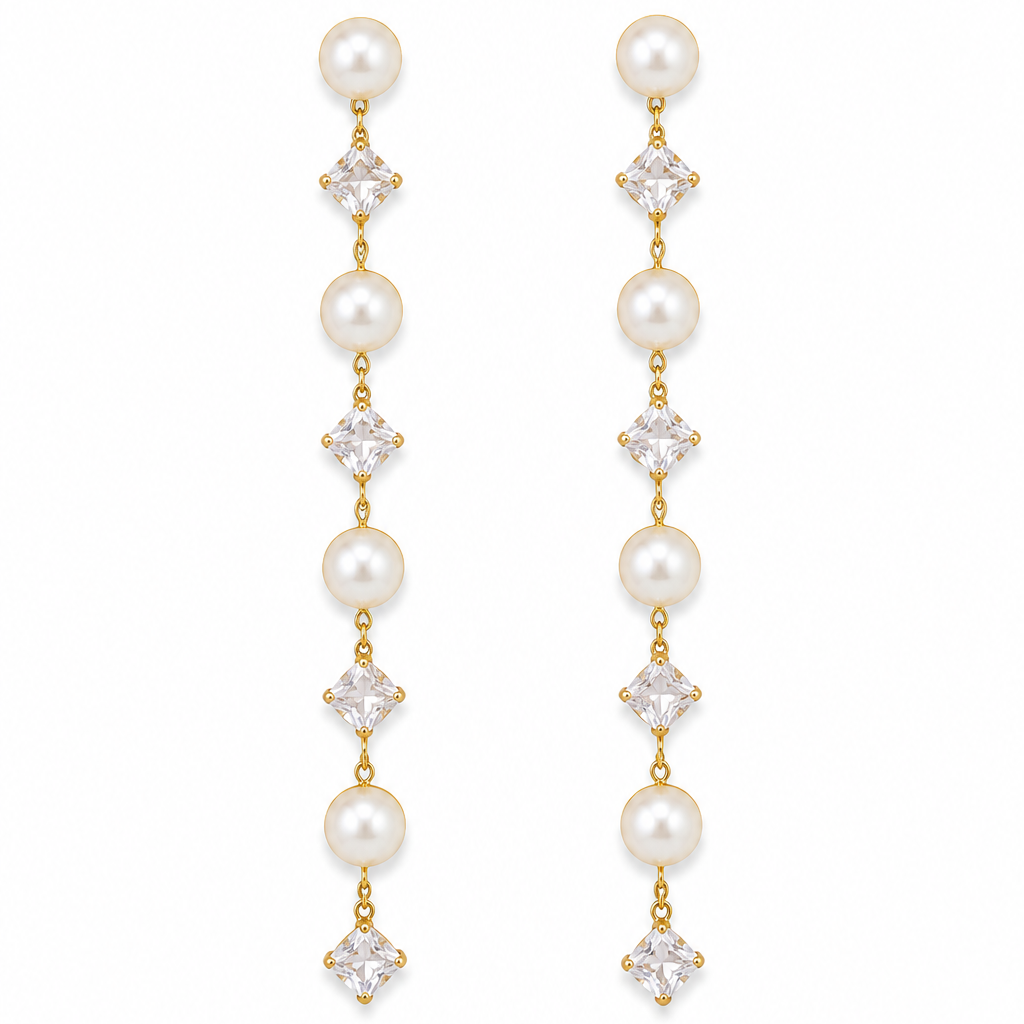 A pair of gold drop earrings featuring white pearls and clear square-cut crystals, arranged vertically on a plain white background.