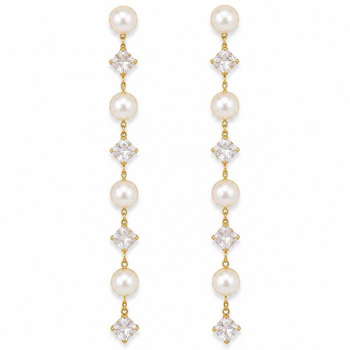 A pair of gold drop earrings featuring white pearls and clear square-cut crystals, arranged vertically on a plain white background.