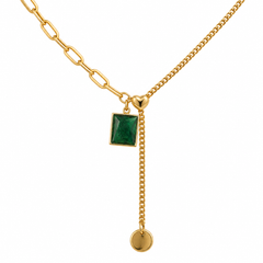 Gold chain necklace featuring a rectangular green gemstone pendant, a small gold heart, a dangling chain with a round gold disc charm, and a paperclip link detail, shown on a white background.
