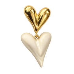 A heart-shaped pendant jewelry piece featuring a polished gold top heart and a textured cream-colored bottom heart, suspended from a gold ring on a plain white background.