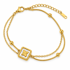 A gold double-strand chain bracelet featuring a square charm with a butterfly motif on a white inlay, accented with small gold beads, shown on a plain white background.