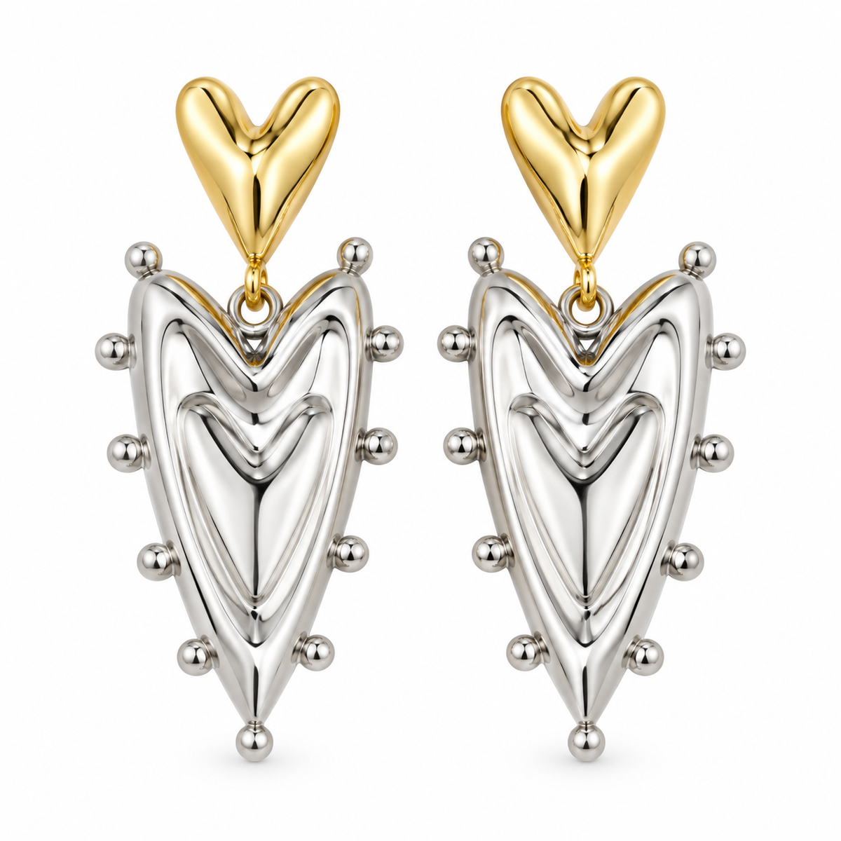 A pair of dangling earrings with polished yellow gold heart-shaped studs and silver-toned teardrop charms outlined with small metallic beads, shown on a plain white background.